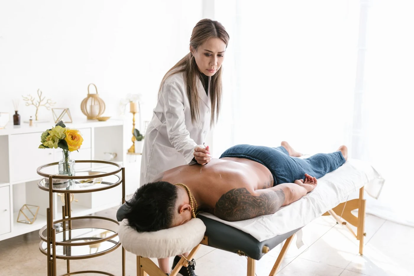 A practitioner carrying out an acupuncture session; illustrative stock photography